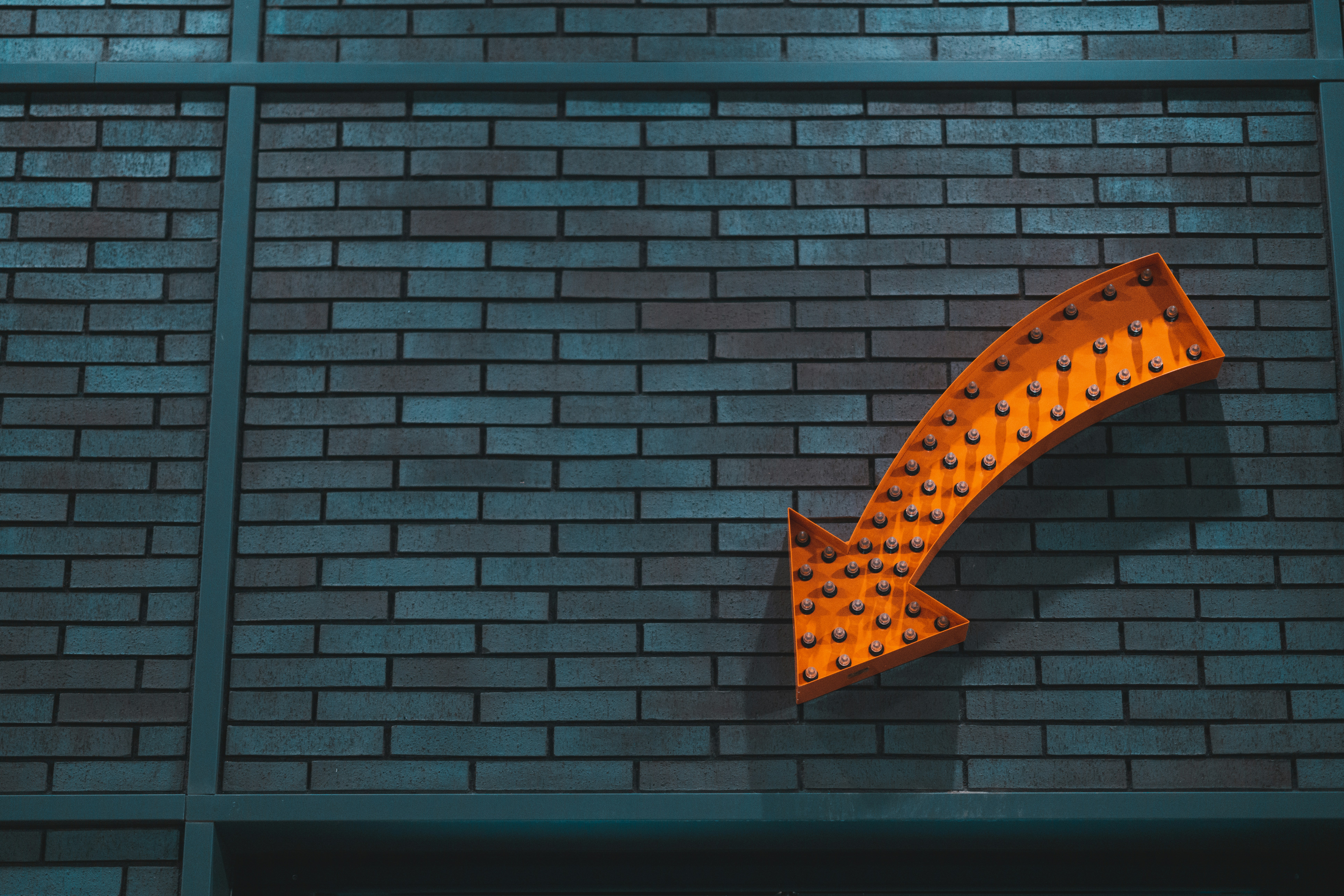 Banner image of a brick wall and orange arrow